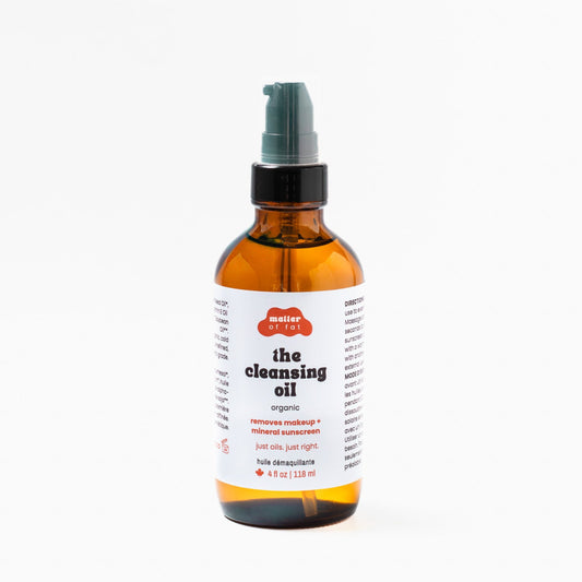 Amber 4 oz glass pump bottle of 'the cleansing oil' on a white background