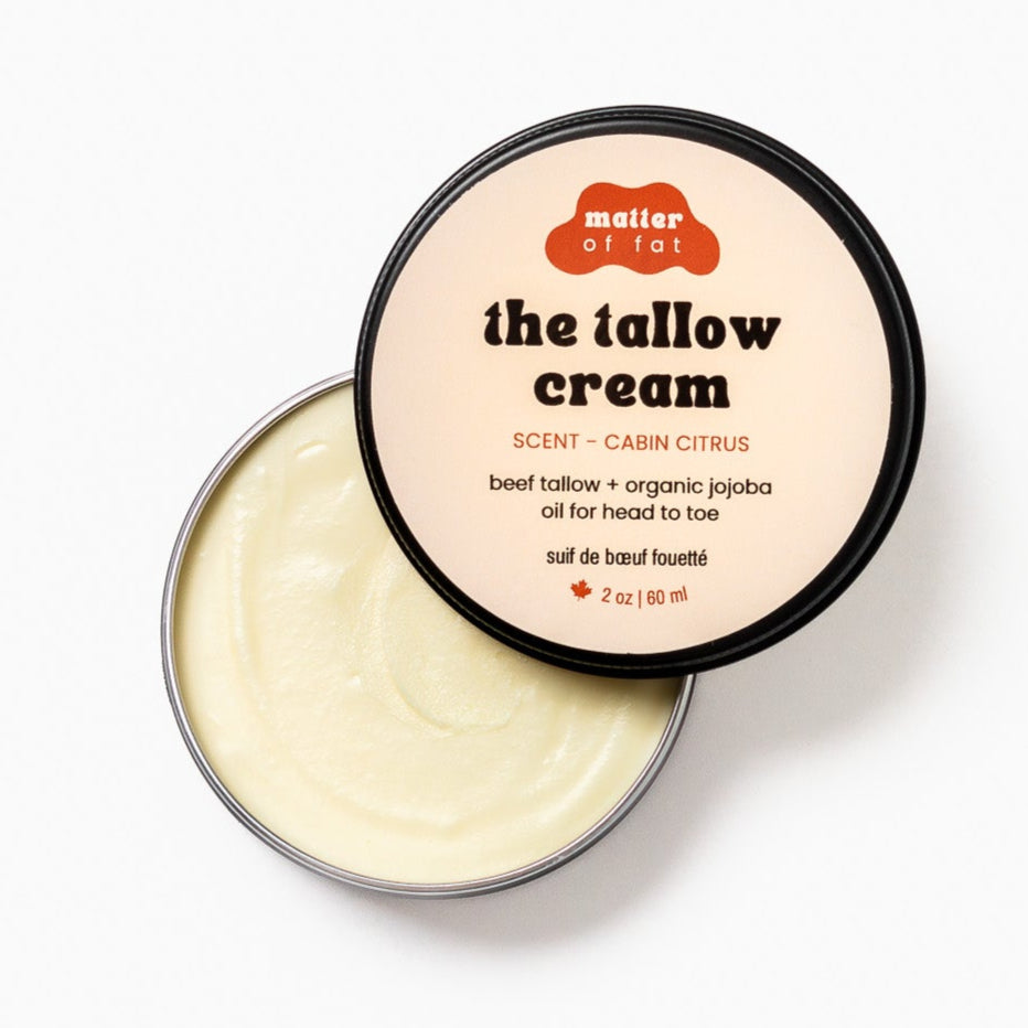 The Cabin Citrus tallow cream in a 2 ounce tin with 'matter of fat' branding on a white background. Can view 3/4 of the open tin tallow. 